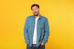 A man is standing upright in front of a vibrant yellow background. He appears confident and focused. The bright color of the backdrop creates a striking contrast with the mans silhouette. photo