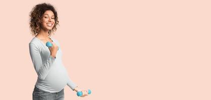 Pregnancy fitness. African-american pregnant girl exercising with dumbbells over white background, panorama with copy space photo