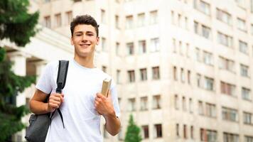 Education concept. Student guy walking near university, waiting for classes, free space photo