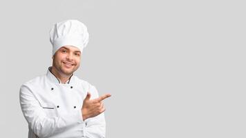 Look There. Cook Man Pointing Finger Aside At Copy Space Over Gray Studio Background. Panorama photo