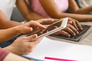 Modern source of information. Focused student using tablet and turning page in library, close up photo