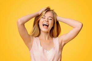 Expression Of Joy. Young girl emotionally shouting with closed eyes, standing over yellow background in studio, copy space photo