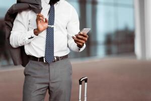 Order Taxi. Businessman Using Mobile Phone, Arriving At Airport, Crop photo