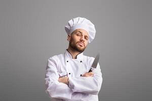 Professional Chef. Strict Cook Man Holding Knife Looking Severely At Camera Posing Over Black Background In Studio. Panorama photo