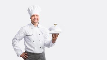 Chef Man Posing With Plate Smiling To Camera Standing Over White Background. Studio Shot photo