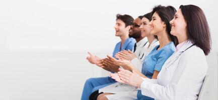 General Practitioners Applauding To Successful Lecturer, Sitting In Conference Room photo