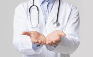 Closeup of unrecognizable doctor holding invisible object on his open palms, standing over white background, cropped image photo