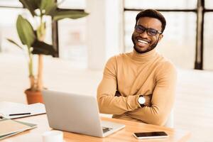 Successful Businessman. Happy black man smiling and sitting with crossed arms. Free space photo