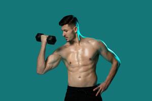 A man standing in front of a green background, holding a dumbbell in his hand. He appears focused and determined as he engages in a weightlifting exercise. photo