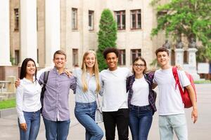 Student life. Classmates posing in front of university and smiling to camera photo