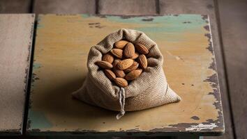 Rustic Burlap Sack of Almonds on Wooden Table for Natural Food and Diet Concepts. photo