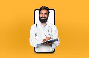 Smiling young eastern man doctor with a clipboard, presented within a smartphone frame, illustrating a user-friendly telehealth app interface photo