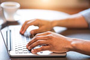A person is actively typing on the keyboard of a laptop. Their fingers are moving quickly and purposefully, possibly working on a project or communicating with others, cropped photo