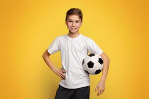 Kid in white t-shirt holding soccer ball on orange panorama background with empty space photo