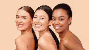 Beauty And Skincare. Portrait Of Three Multiethnic Girls Smiling At Camera Posing Over White Studio Background. Panorama photo