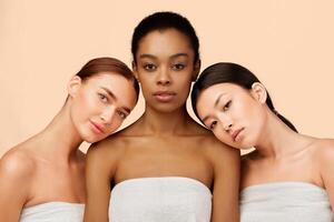 Three Sensual Multicultural Girls Wrapped In Bath Towels Posing Over White Background. Studio Shot photo