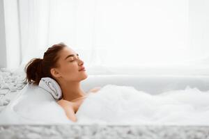 Relax Concept. Woman Enjoying Hot Bath With Foam, Resting After Work Day photo