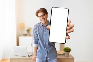 Hey, You. Smiling Man Pointing Finger At Camera Standing Indoors. Free Space For Text photo