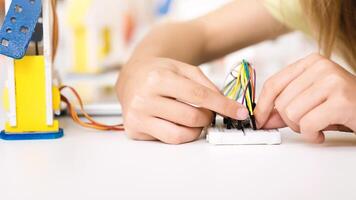 A young person is shown working on a STEM project, connecting colorful wires to a breadboard. The image captures their focused concentration as they learn about electronics and circuits. photo