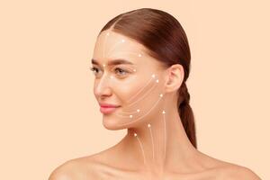 Facelift Routine. Portrait Of Young European Lady With Lifting Arrows Lines On Face Over White Studio Background, Looking Aside. Effortless Facial Skincare And Anti Aging Renewal Treatment Concept photo