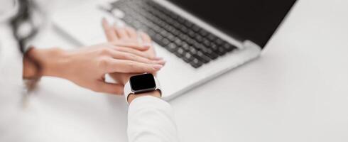 Time Management Concept. Young businesswoman checking smart watch. Mock up, copy space photo