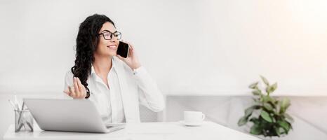 Talkative Businesswoman. Happy mexican manager talking on smartphone during coffee break. Panorama, copy space photo