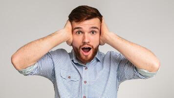 Angry with nosy neighbors. Portrait of irritated man shouting and covering his ears on studio background, panorama photo