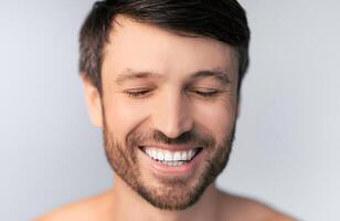 Middle Aged Man Smiling With Closed Eyes Posing Over White Background In Studio. Shallow Depth, Selective Focus photo