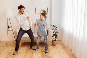 Father And Son. Happy Man And His Kid Having Fun Dancing And Fooling Around At Home. Free Space For Text photo