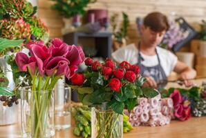 Small business. Male florist unfocused in flower shop. Floral design studio, making decorations and arrangements. Flowers delivery, creating order photo