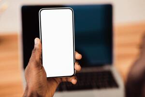 Useful App. Close-up of black man holding mobile phone with white blank screen. Mock up, rear view photo