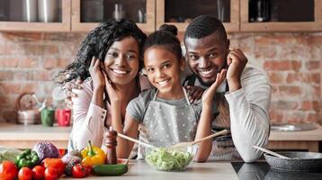 Lovely black family cooking healthy dinner together at kitchen, posing at camera, making salad, panorama with copy space photo