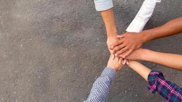 Unity concept. Multiracial students joining hands together in cooperation, top view, free space photo