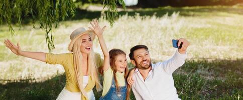 Summer Fun. Happy Family On Picnic Making Selfie Spending Sunny Day Together In Nature Outdoor After Quarantine And Parks Reopening. photo