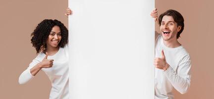 Happy Interracial Couple Holding White Advertising Board And Showing Thumbs Up, Recommending Something Over Yellow Studio Background, Free Space photo