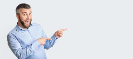 A man wearing a blue shirt is pointing at an unseen object in the distance. He appears to be directing attention or indicating a specific direction, panorama with copy space photo
