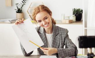 Making For Vlog. Happy stylish designer showing her sketch to camera, working at home, copy space photo