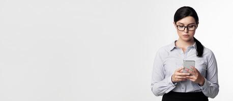 Business Chat. Serious Businesswoman Using Cellphone Texting Standing On White Background. Studio Shot, Empty Space photo