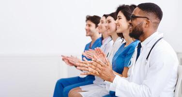 Medical Education. Doctors And Interns Clapping Hands At Conference, Looking At Empty Space photo