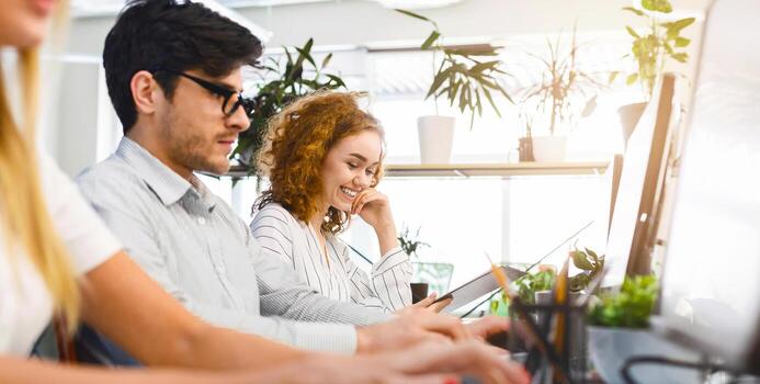 Tech Team Brainstorming in Contemporary Workplace. Tech-savvy group brainstorming ideas at their laptops, creating a creative and inspiring atmosphere in a contemporary workspace. photo