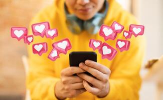 The image shows a person using a smartphone, with numerous heart icons floating around them, suggesting they are receiving a lot of attention or likes on social media photo