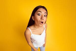 Wow. Surprised Asian Lady With Funny Expression Posing On Yellow Background, High Angle View photo