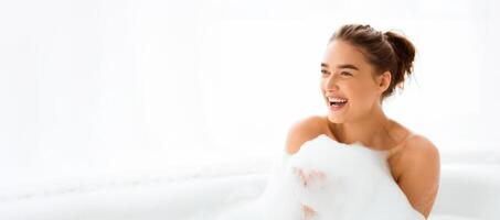 Beautiful woman taking relaxing bath with foam and playing with soap bubbles photo