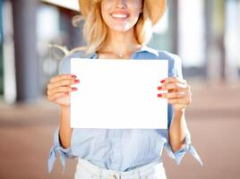 Pretty woman holding empty placard outside the airport, copy space for text photo