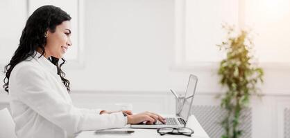 Home Office. Side view of happy hispanic manager using laptop, working remotely. Copy space photo
