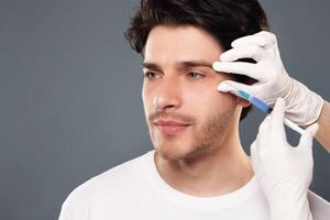 Beauty injection for men. Millennial guy getting surgery filling of facial wrinkles, empty space photo