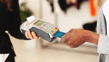 African American woman is making a payment using a credit card. The man is receiving the transaction. Both individuals are engaged in the financial exchange, cropped photo