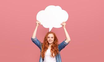 A woman standing and holding a speech bubble above her head, possibly symbolizing communication, speech, or expression. The speech bubble is blank, suggesting the opportunity for a message or dialogue photo
