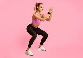 Workout. Young Woman Doing Deep Squat Exercise Over Yellow Studio Background. Copy Space photo