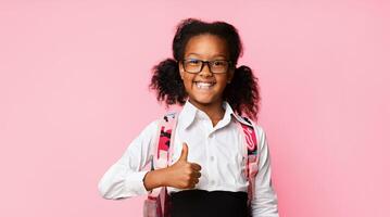 Cheerful Black School Girl Gesturing Thumbs-Up Smiling To Camera Posing Over Yellow Studio Background. I Like School Concept. Panorama photo